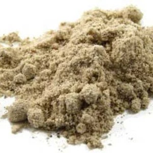 May include: A close-up of a pile of light brown powder. The powder is finely ground and has a slightly grainy texture.