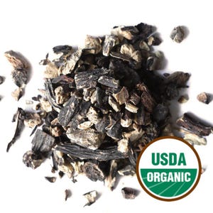 Könnte beinhalten: Nahaufnahme von getrockneten, gehackten schwarzen Schwarzwurzelstücken, mit einem USDA Organic-Siegel. Die Stücke sind in verschiedenen Größen und Formen gehalten, mit dunkelbraunen, schwarzen und beigen Farben.