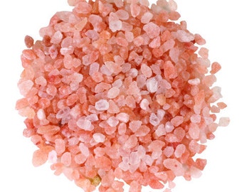 May include: A close-up view of pink Himalayan salt crystals. The salt is a light pink color and has a rough, irregular texture.
