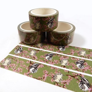 May include: Three rolls of green washi tape with a white border and a repeating pattern of black and white birds on pink blossoms.