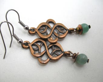 May include: Copper Celtic knot earrings with green gemstone beads. The earrings have a silver hook closure.