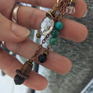 Closeup of long boho pendant. 8mm lava bead, 6mm lava, 6mm turquoise and glass crystal charms by JT Maui Designs