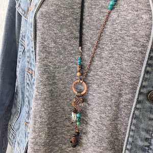 Long boho style necklace with solid copper one inch cirlce and multiple dangles in turquoise and lava, and quality glass crystal and wood.