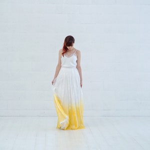 May include: A woman wearing a white and yellow ombre wedding dress with a lace bodice.