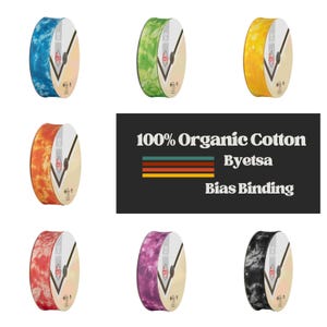 May include: A collection of bias binding rolls in various colors, including blue, green, yellow, orange, red, purple, and black. The rolls are labeled with "100% Organic Cotton Byetsa Bias Binding."