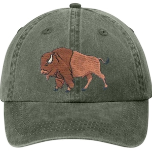 May include: A green baseball cap with an embroidered image of a brown bison. The bison has a light brown body and a darker brown head. The cap is made of a soft, worn material.