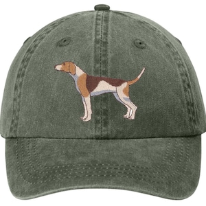 May include: A green baseball cap featuring an embroidered image of a dog. The dog is depicted in shades of brown, white, and tan. The cap has a curved brim and an adjustable strap at the back.