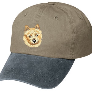 May include: A brown and gray baseball cap with an embroidered image of a Norwich Terrier dog on the front.