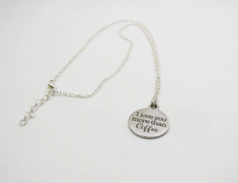 May include: A silver necklace with a round pendant that says "I love you more than Coffee".