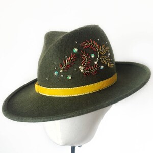 May include: A green felt fedora hat with a yellow ribbon and a beaded floral design.