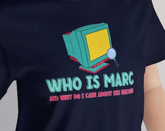 May include: A navy blue t-shirt with a graphic of a computer screen and magnifying glass. The text on the shirt reads "Who is Marc and why do I care about his record?"