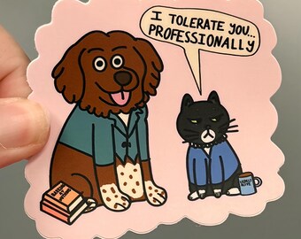 May include: A die-cut sticker on a light pink background featuring a brown dog in a teal blazer next to a stack of books titled BARKING AT NOTHING and a black cat in a blue blazer with a mug, with the text I TOLERATE YOU... PROFESSIONALLY.