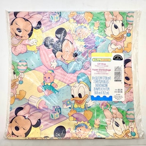 May include: Gift wrap featuring Disney Babies characters, including Mickey and Minnie Mouse, Donald and Daisy Duck, in a pastel design. The wrapping paper is packaged in a clear plastic sleeve. Dimensions: 50.8 cm x 76.2 cm.
