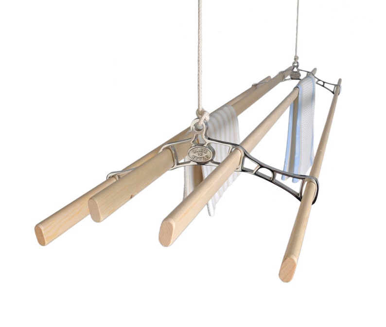 May include: A ceiling mounted clothes drying rack with four wooden rods and a chrome finish. The rack is suspended from the ceiling by a rope and pulley system. Two towels are hanging on the rack.