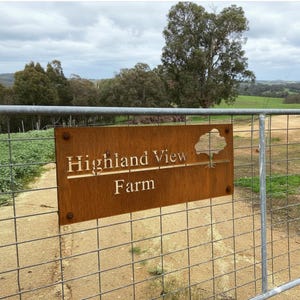 Custom Corten Steel Farm Sign, Personalized Metal Barn Plaque shown in an AI-generated listing photo