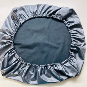 May include: A gray round cover with a drawstring closure. The cover is made of a water-resistant material.