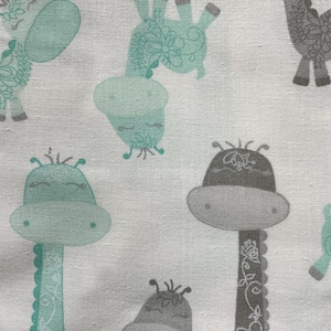 May include: White fabric with a repeating pattern of gray and teal giraffes. The giraffes have a whimsical, cartoon-like design with floral details.