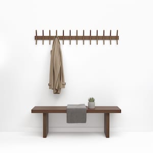 Elegante perchero de nogal: organizador minimalista de estilo de mediados de siglo para la entrada, con ganchos para sombreros y abrigos.