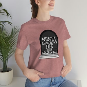 Puede incluir: Una camiseta de color rosa heather con un gráfico en blanco y negro de una puerta con el texto "Nesta Archeron's 10K Stair Challenge".
