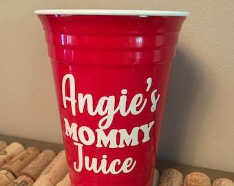 May include: Red plastic cup with white lettering that says "Angie's Mommy Juice".