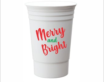 May include: White plastic cup with the text "Merry and Bright" in red lettering.