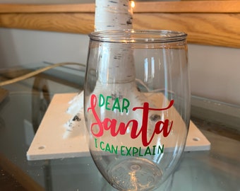May include: Clear glass wine glass with a red and green vinyl decal that says "Dear Santa I can explain".