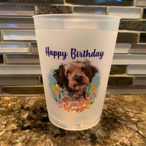 May include: White plastic cup with a personalized design featuring a brown and white dog with the text "Happy Birthday" and the name "Scruffy" in blue.