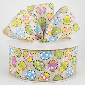 May include: A roll of brown burlap ribbon with a white background and colourful Easter egg designs. The ribbon is 2.5 inches wide and has a wired edge.