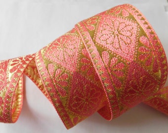May include: Pink and gold ribbon with a floral pattern. The ribbon is woven with a metallic gold thread.