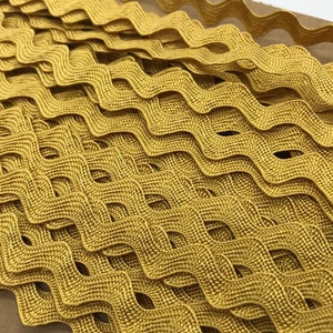 May include: Gold wavy trim with a woven texture. The trim is approximately 1/2 inch wide.