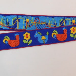 May include: Two strips of decorative ribbon with a blue background and a red border. One ribbon features a repeating pattern of blue and orange abstract shapes. The other ribbon has a pattern of rooster, horse, and flower designs.