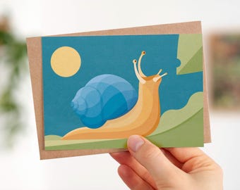 May include: A greeting card featuring a cartoon snail with a blue shell and a yellow body. The snail is on a green leaf with a yellow sun in the background.