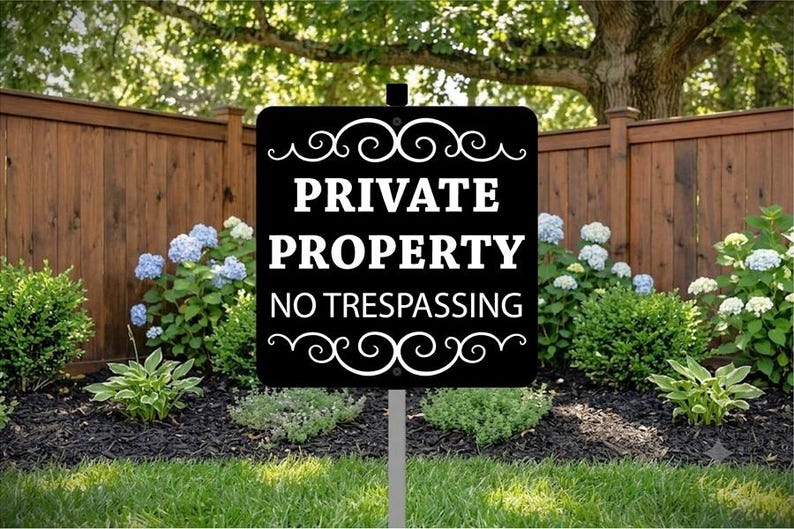 May include: A rectangular black sign with white text that reads PRIVATE PROPERTY NO TRESPASSING. The sign features decorative white scrollwork at the top and bottom edges and is mounted on a single gray metal stake centered at the bottom.
