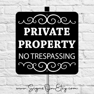 May include: A square black sign with white text that reads PRIVATE PROPERTY NO TRESPASSING. The sign features white decorative scrollwork borders at the top and bottom, and it is mounted on a vertical pole. The text is clear and centered on the sign.