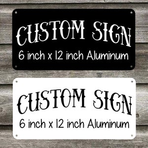 May include: Two metal signs, one black and one white, with the text "CUSTOM SIGN" and "6 inch x 12 inch Aluminum".