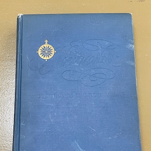 May include: A vintage blue book titled "Europe's Complete World Atlas." The cover features gold lettering and a gold compass rose emblem. The book shows signs of wear, suggesting it is an antique.