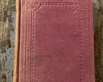 May include: A vintage, purple-colored book with a decorative, embossed border. The book has a worn, aged appearance.