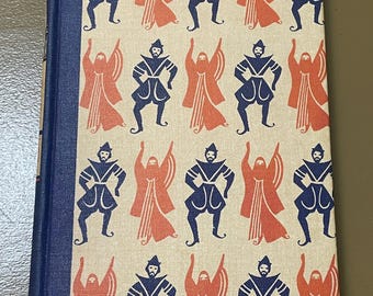 May include: A vintage book with a blue spine and a cream-colored cover. The cover features a repeating pattern of stylized figures in navy blue and coral. The figures include a man and a robed figure.