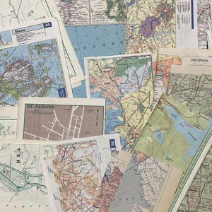 May include: A collection of vintage maps, including state maps of Maine and Georgia, and a city map of St. Albans. The maps feature detailed road networks, geographical features, and place names, with a variety of colors and styles.
