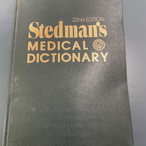 May include: A hardcover book titled "Stedman's MEDICAL DICTIONARY" in gold lettering on a dark green cover. The text "22nd EDITION" is above the title. The book has a textured appearance.