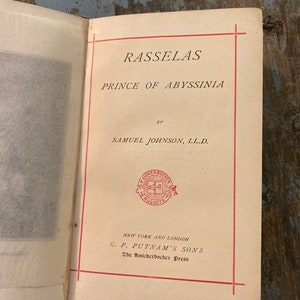 May include: A vintage book titled "Rasselas, Prince of Abyssinia" by Samuel Johnson, LL.D. The book is published by G.P. Putnam's Sons, The Knickerbocker Press, New York and London.