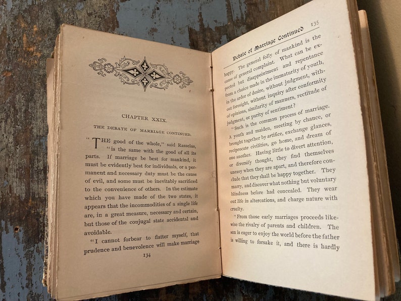 May include: An open book with yellowed pages and a brown leather cover. The book is titled "Debate of Marriage Continued" and the text discusses the benefits and drawbacks of marriage.