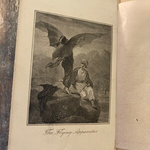 May include: A black and white illustration of a person flying with a large, bat-like apparatus. The person is wearing a long, flowing robe and has a long, flowing beard. The apparatus has large, bat-like wings and a long, thin tail. The illustration is titled "The Flying Apparatus".