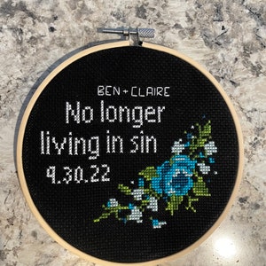 Puede incluir: Aro de bordado negro con texto blanco que dice "Ben + Claire No longer living in sin 9.30.22" y un dise&ntilde;o floral azul y verde.