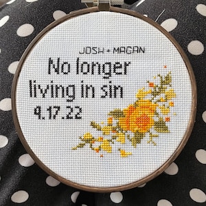 Puede incluir: Un aro de bordado blanco con un dise&ntilde;o floral en amarillo y verde. El texto "No longer living in sin 9.17.22" est&aacute; bordado en hilo negro.