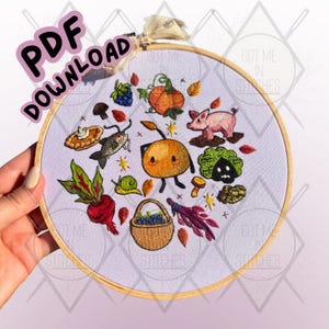 Puede incluir: Un bastidor de bordado cosido a mano con una escena de cosecha otoñal caprichosa. El diseño incluye una calabaza, un cerdo, setas, bayas y una cesta de arándanos. El texto "PDF DOWNLOAD" es visible.