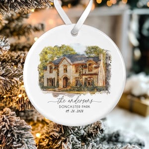 May include: A white round Christmas ornament with a watercolor painting of a house. The text "the andersons DONCASTER PARK 09.24.2024" is printed below the house.
