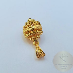 May include: A gold pendant with a round, intricate design. The pendant is made of filigree and has a delicate, ornate look.