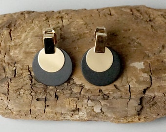 Circular black metal earrings with gold plated disk