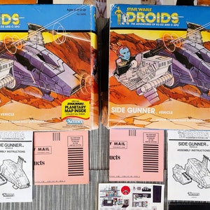 May include: Two Star Wars Droids Side Gunner vehicle boxes with a planetary map inside. The boxes are orange, blue, and white with illustrations of the vehicle and characters. The boxes are accompanied by assembly instructions and a mail order form.